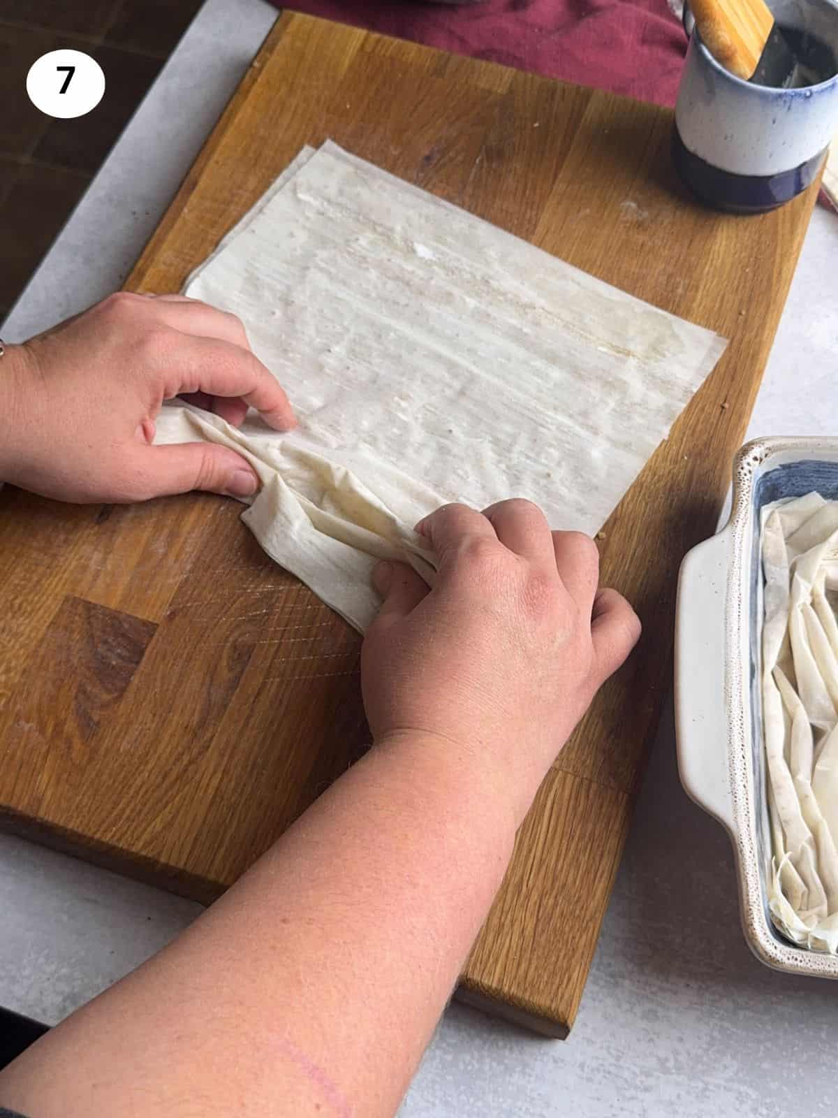 Folding the phyllo sheets like an accordion.