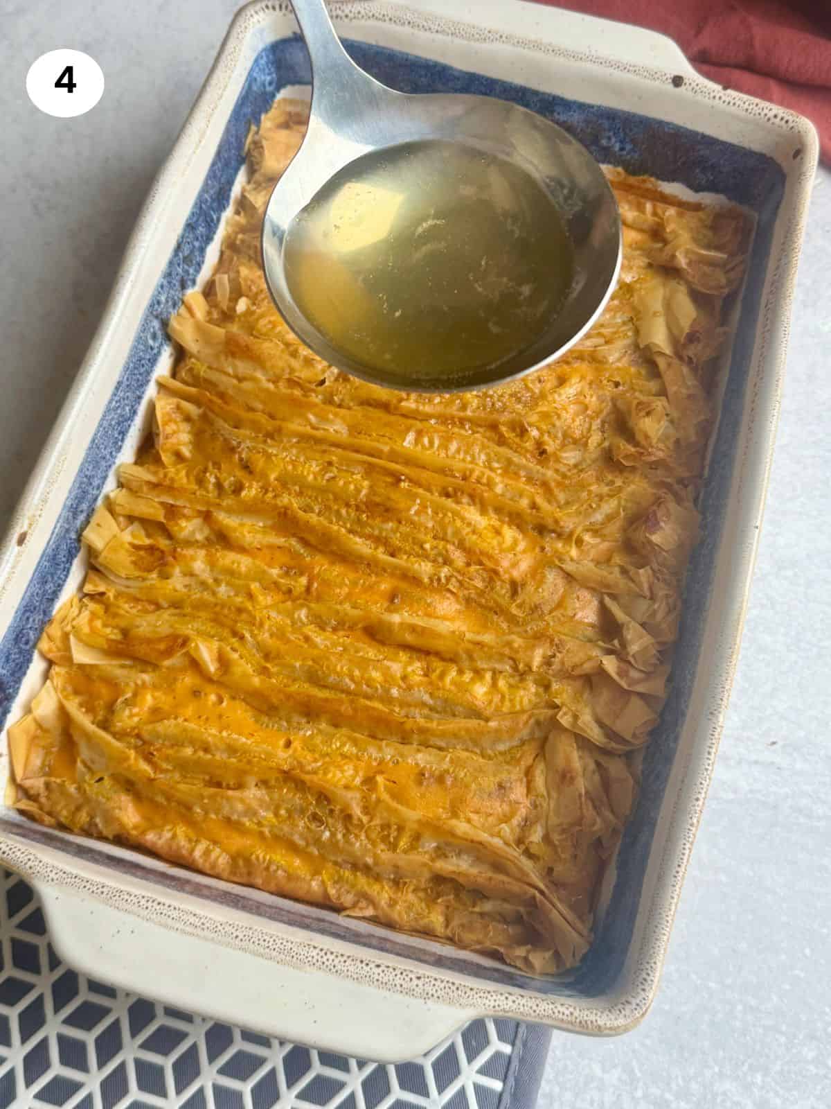 Pouring the syrup on the baked crinkle pumpkin phyllo pie.