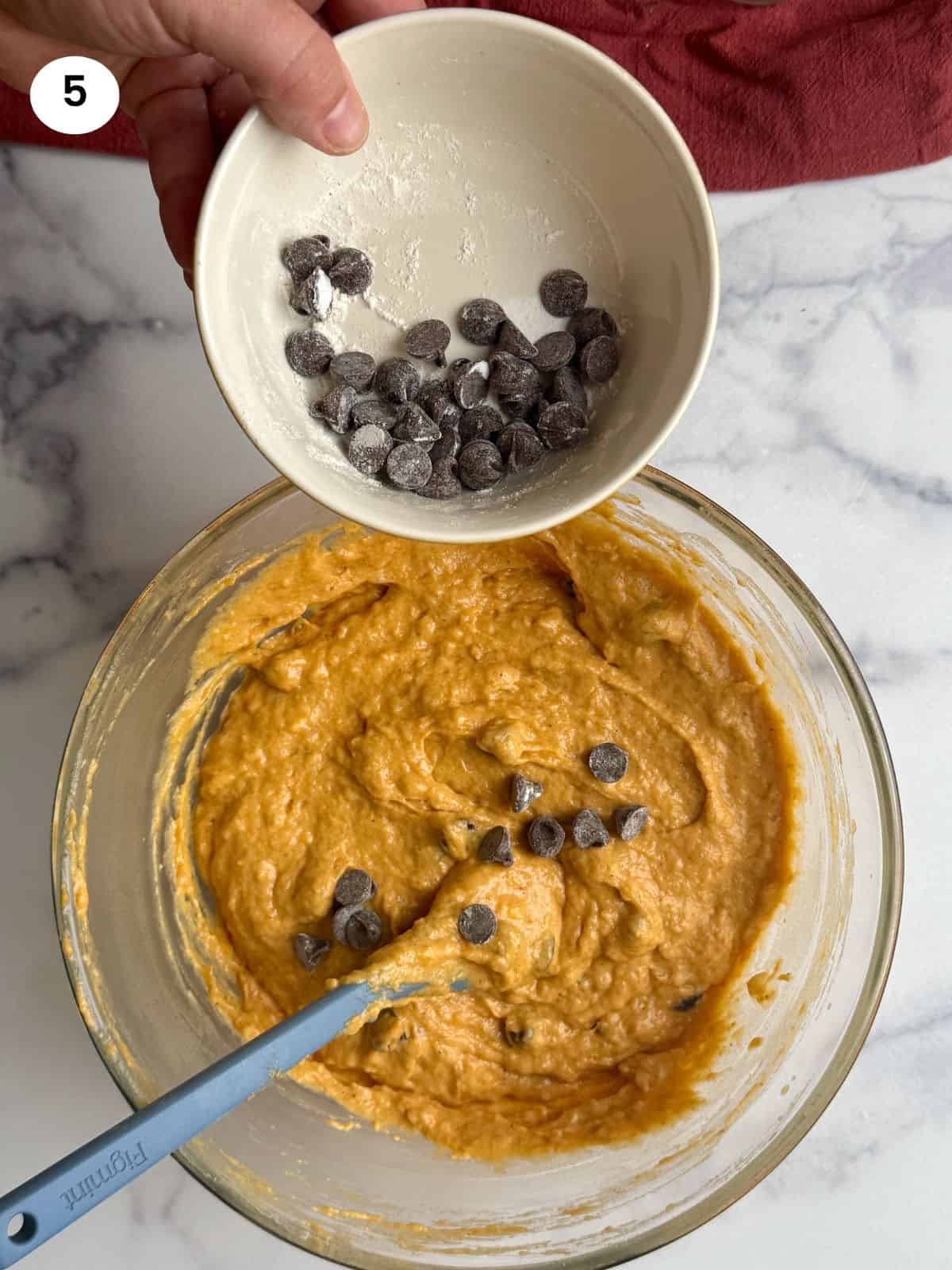 Adding chocolate chips to batter.