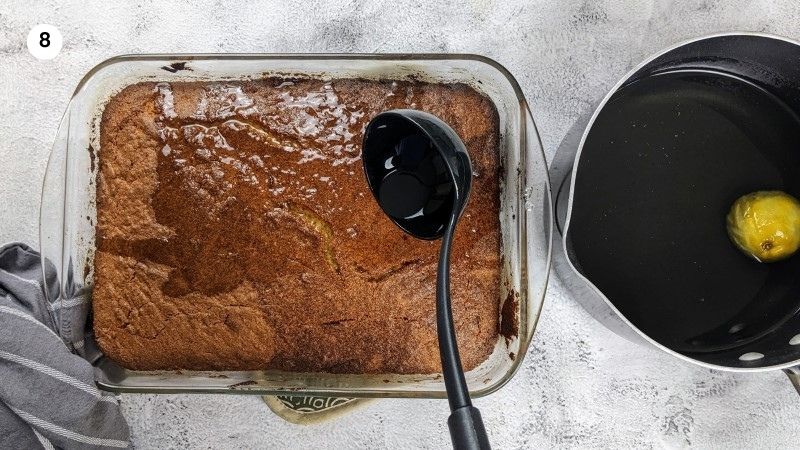 Pouring the syrup over the hot ravani cake.