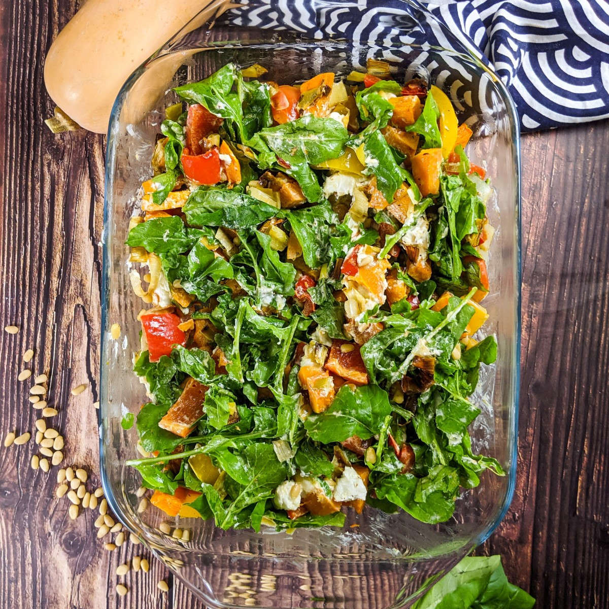 Roasted pepper and butternut squash salad served on a tray next to squash and basil.