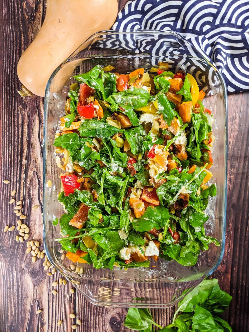 Roasted pepper and butternut squash salad served on a tray next to squash and basil.