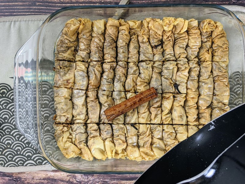 Pouring cold syrup over hot baklava.