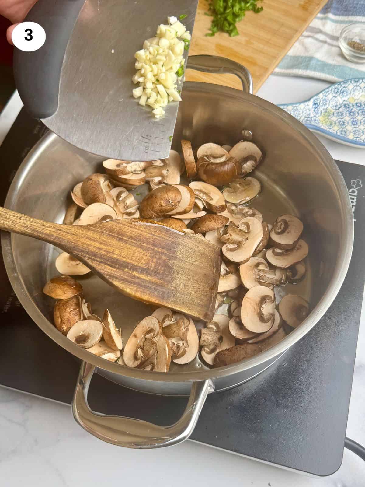 Adding the chopped garlic to the pan.