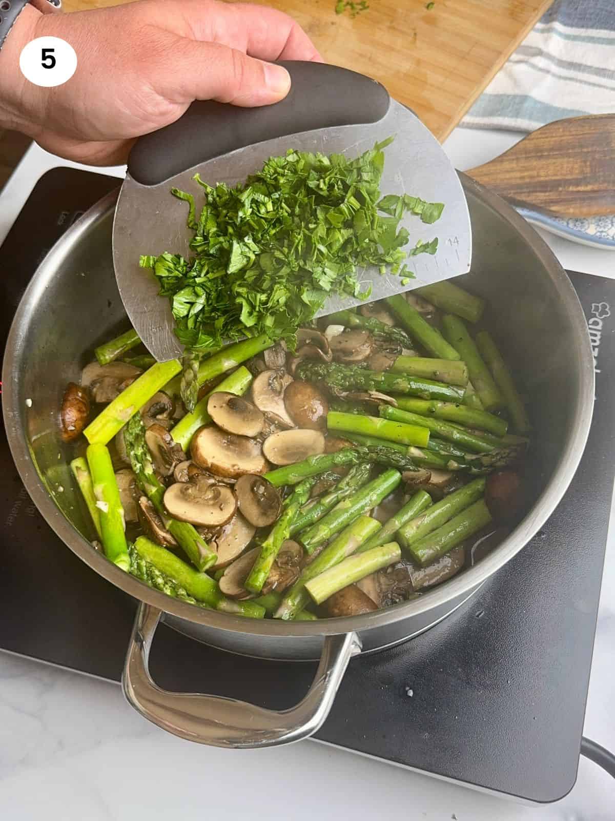 Adding the freshly chopped parsley.