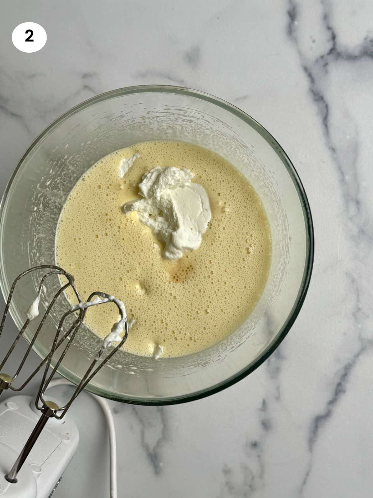 Adding the yogurt and vanilla to the batter.
