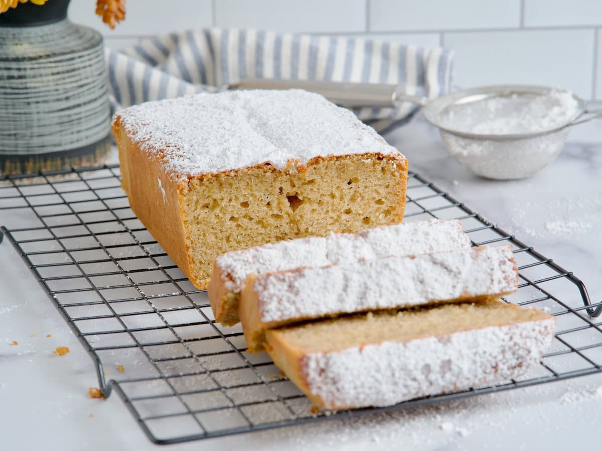 Spiced Greek yogurt pound cake dusted with powdered sugar on a wired rack Spiced Greek yogurt pound cake dusted with powdered sugar on a wired rack.