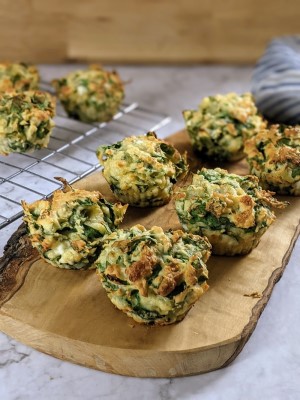 Spinach and cheese muffins on a wooden board.