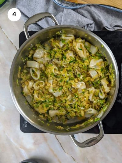 Adding the squid slices to the pot.