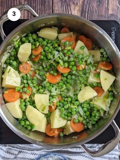 Adding all the chopped veggies and the peas.