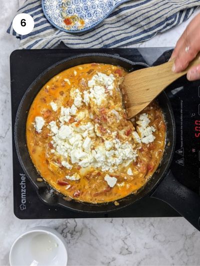 Adding the feta cheese and oregano on top of the eggs.