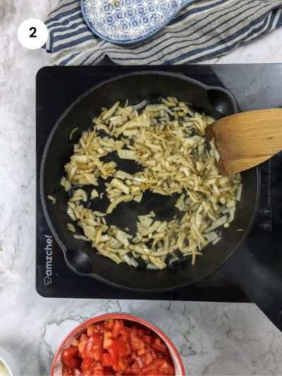 Sauteing the onion cubes until soft and translucent.