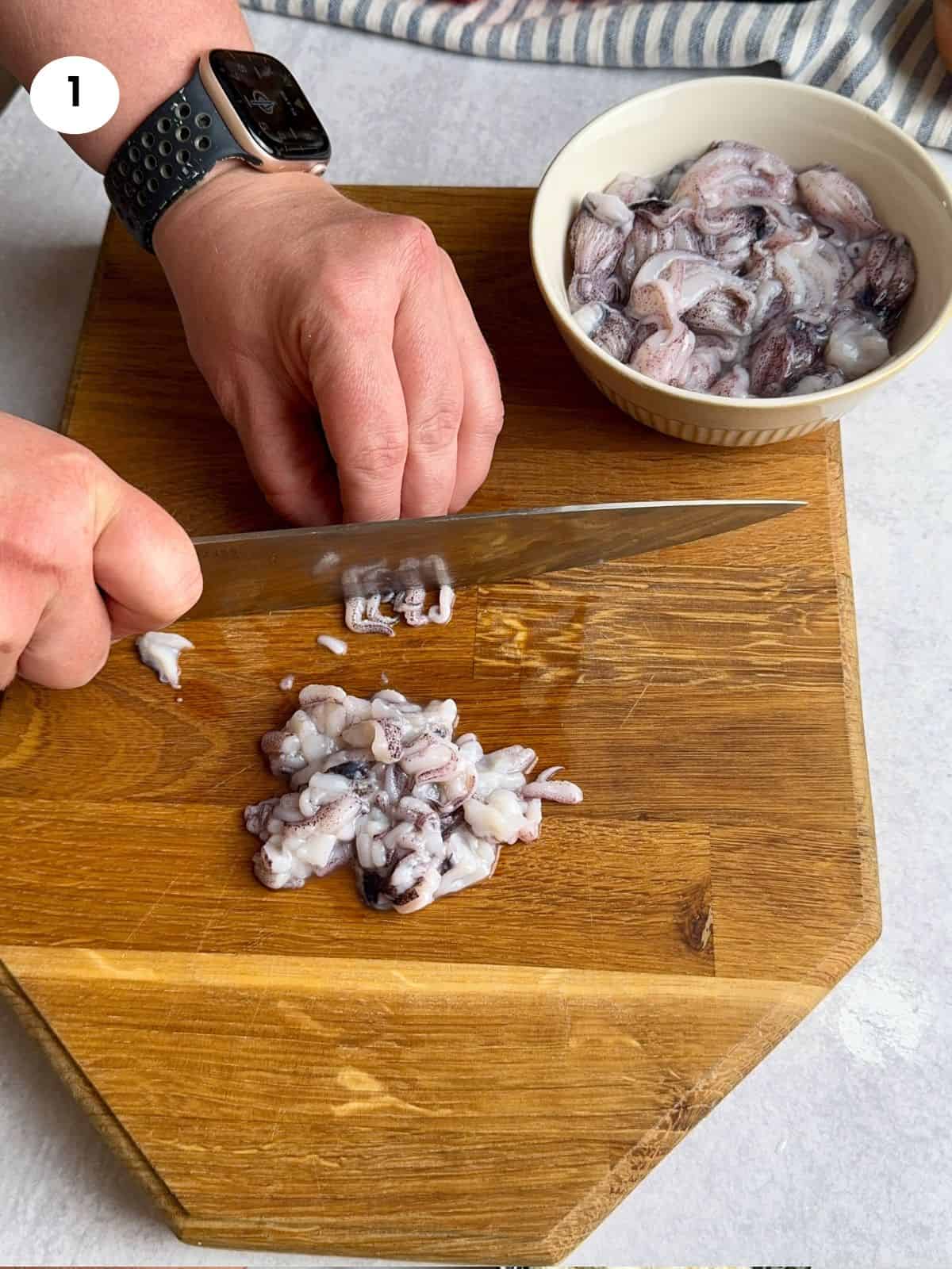 Chopping calamari tentacles.