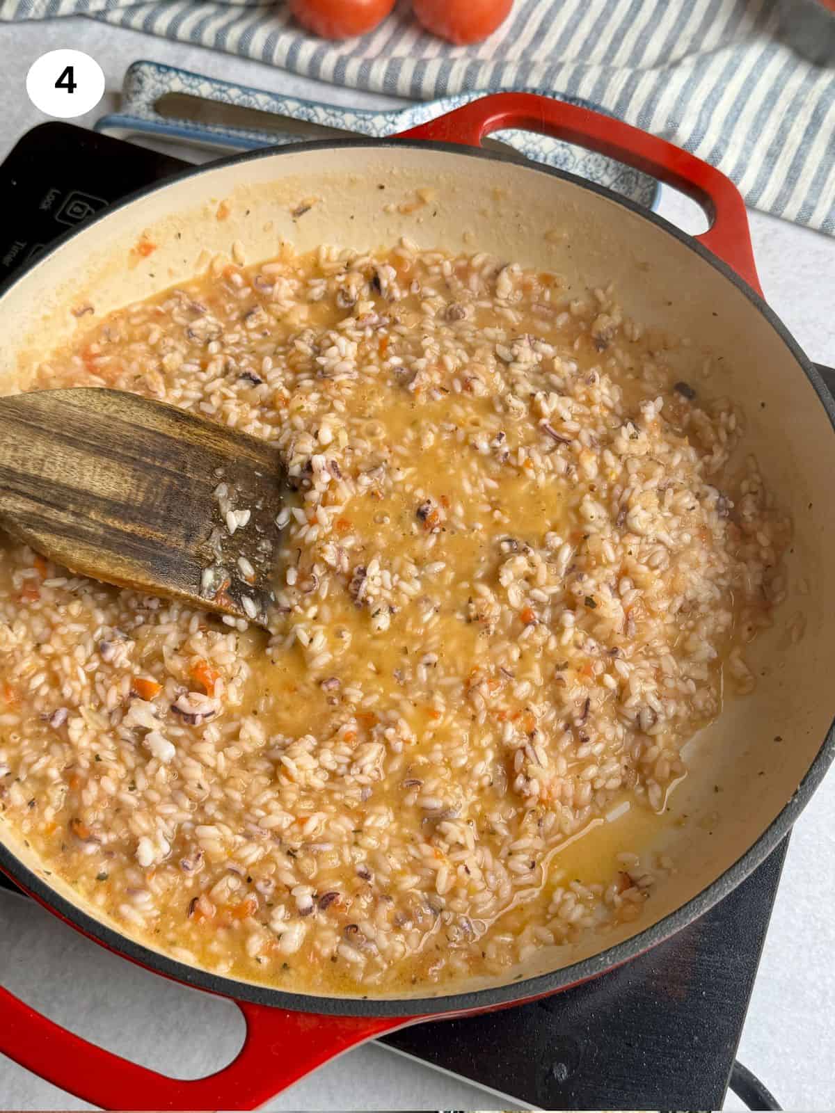 Cooking the rice with the tomatoes and onion.