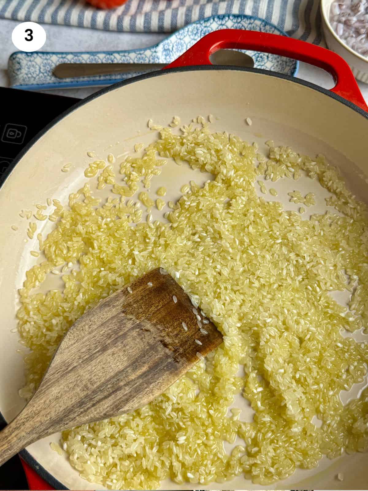 Cooking the rice with oil to seal the grain.