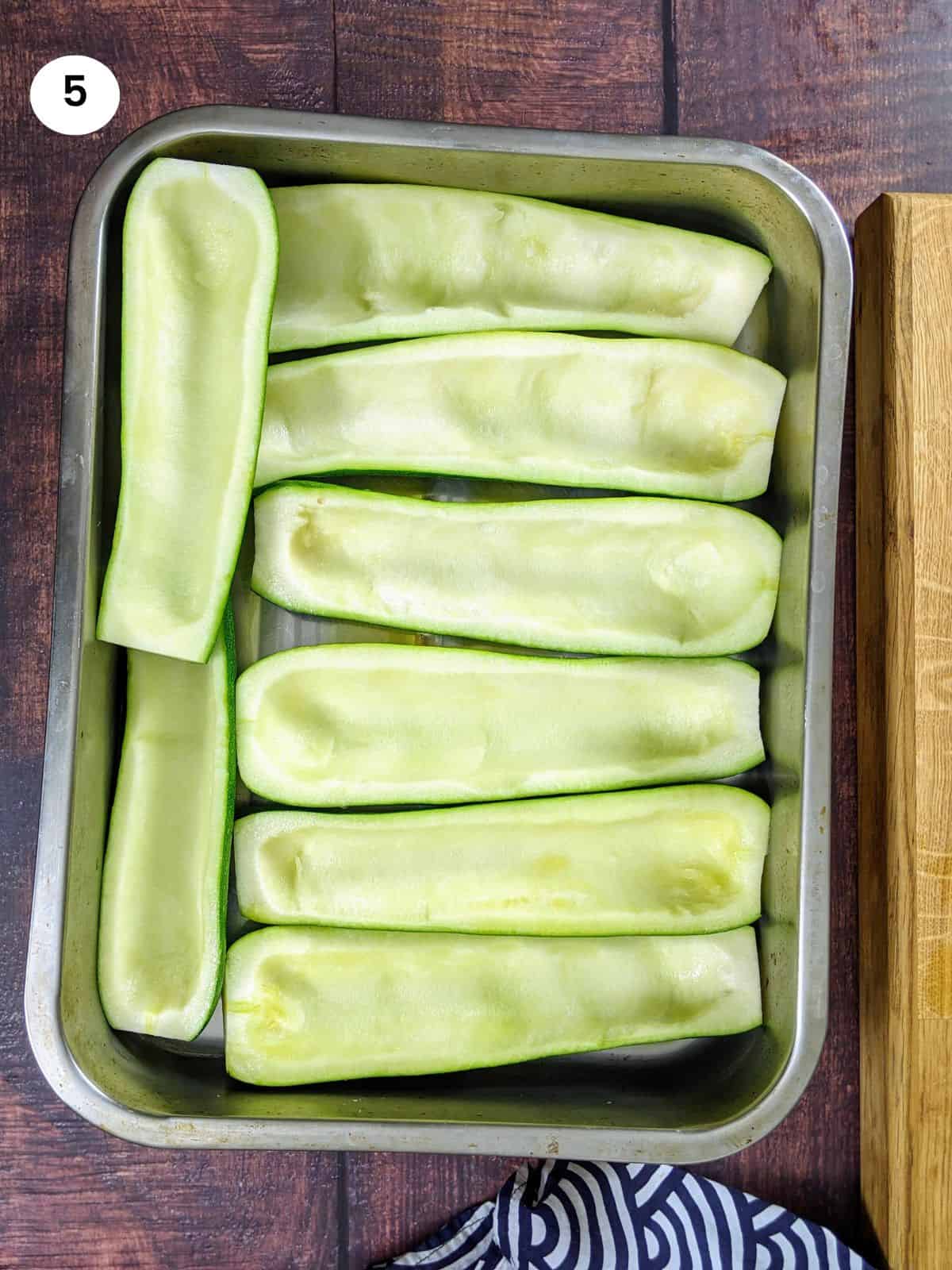 Empty zucchini boats placed in the tray.