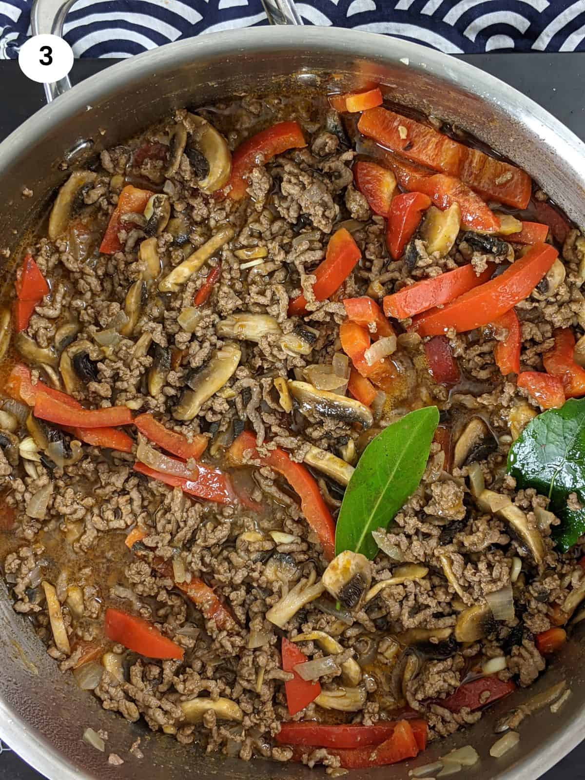 Adding the chopped vegetables for the ground beef filling.