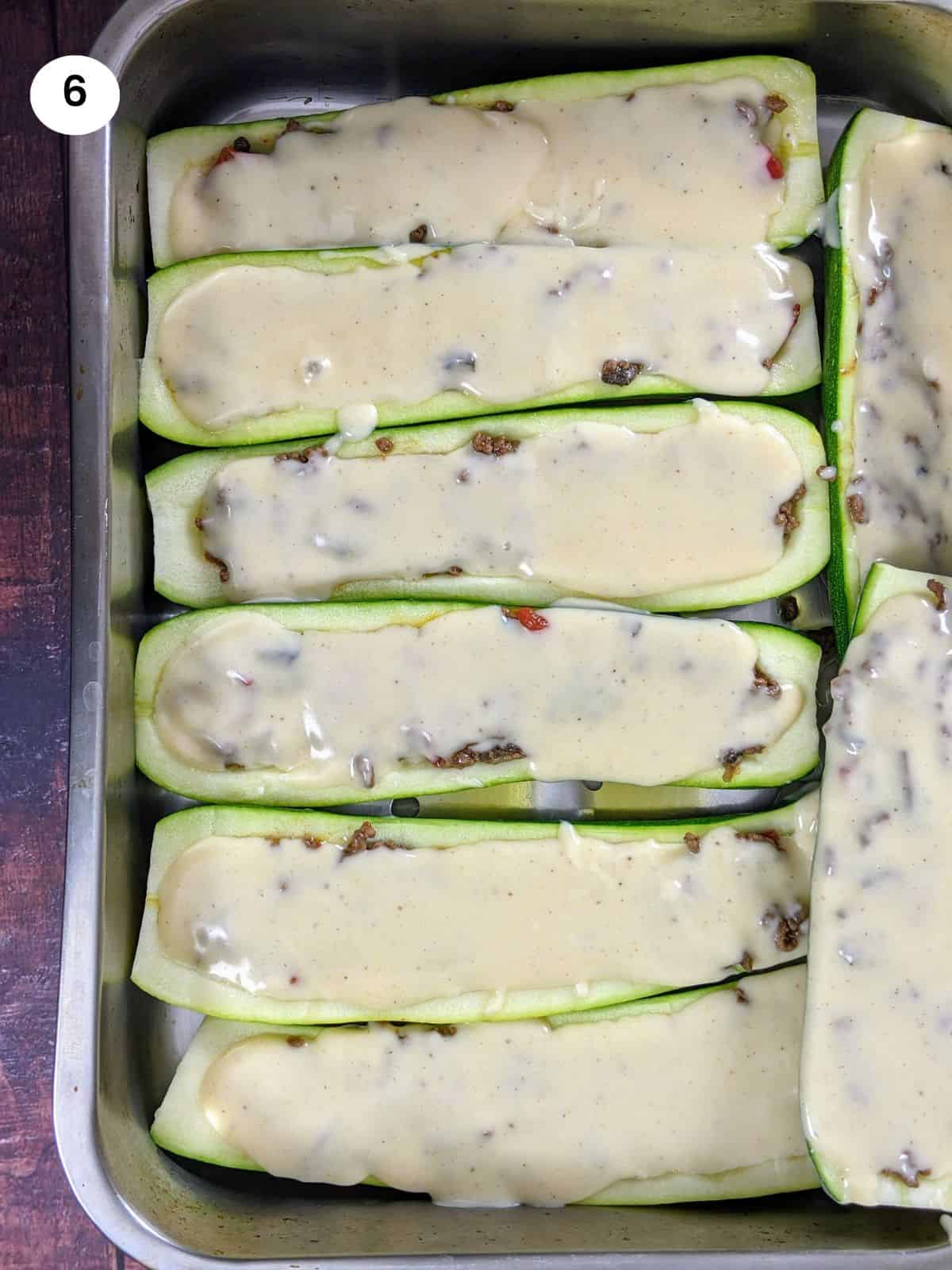 Stuffed zucchini boats with ground beef filling and bechamel sauce on top