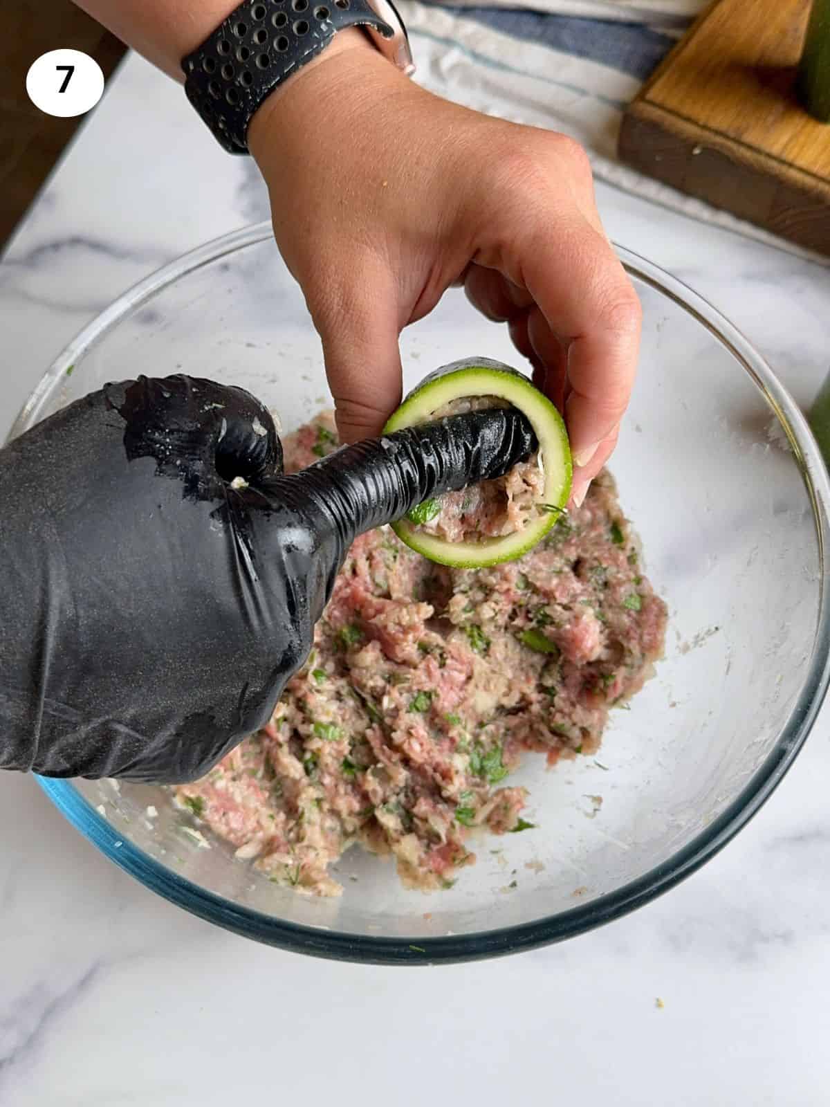 Stuffing the zucchini halves.