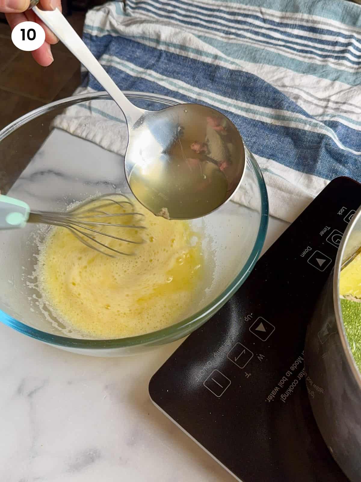 Tempering the eggs with the hot broth.
