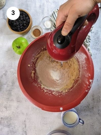 Adding the flour slowly to the mixture for the sugar free blackberry muffins.