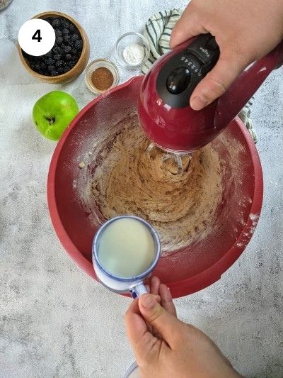 Adding the milk slowly to the mixture.