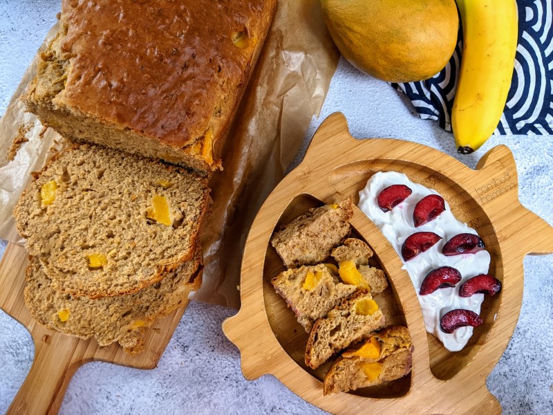 Sugar-free mango bread slice served in bamboo plate for baby with yogurt & berries on the side