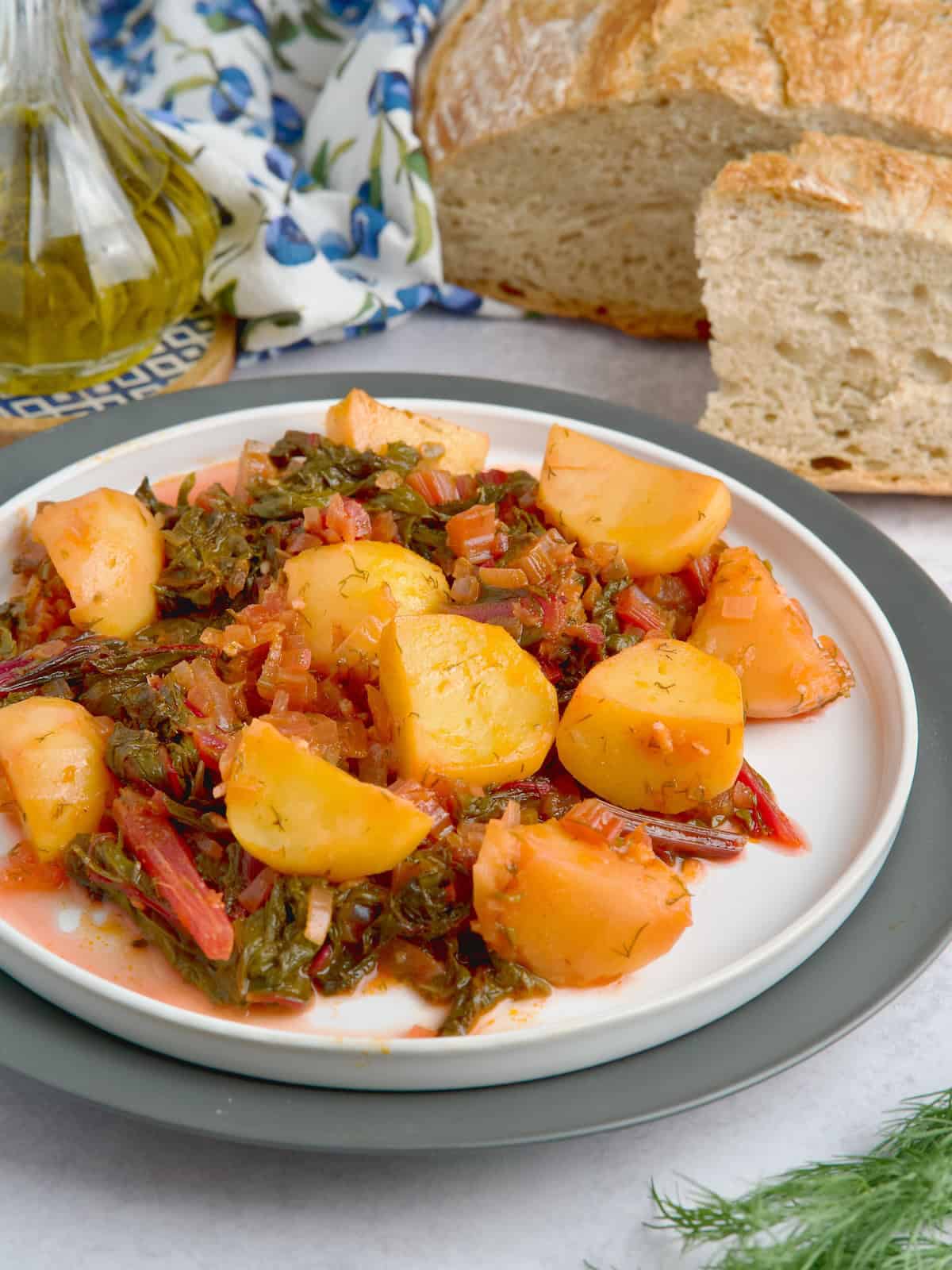 Served swiss chard and potatoes on a white plate Served swiss chard and potatoes on a white plate.