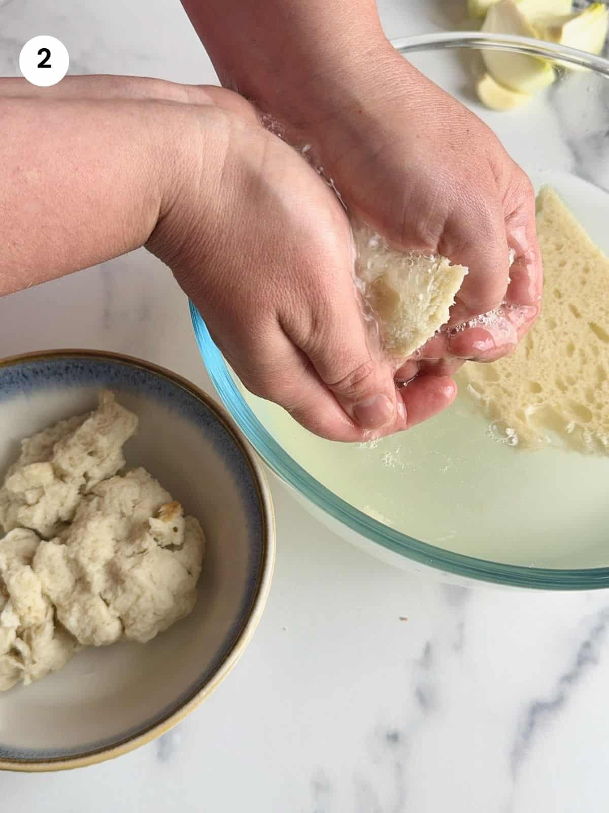 Squeezing the water out of the bread slices.