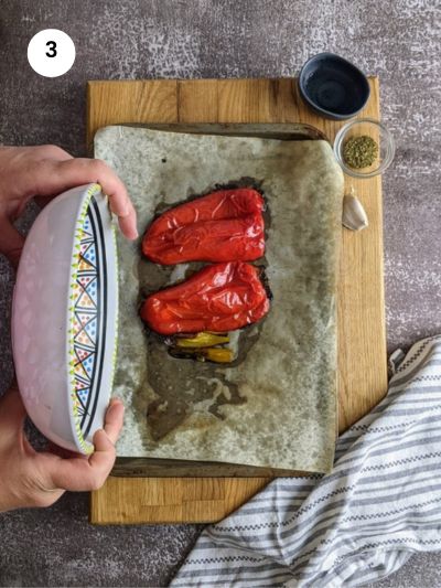 Covering the roasted peppers with a bowl.