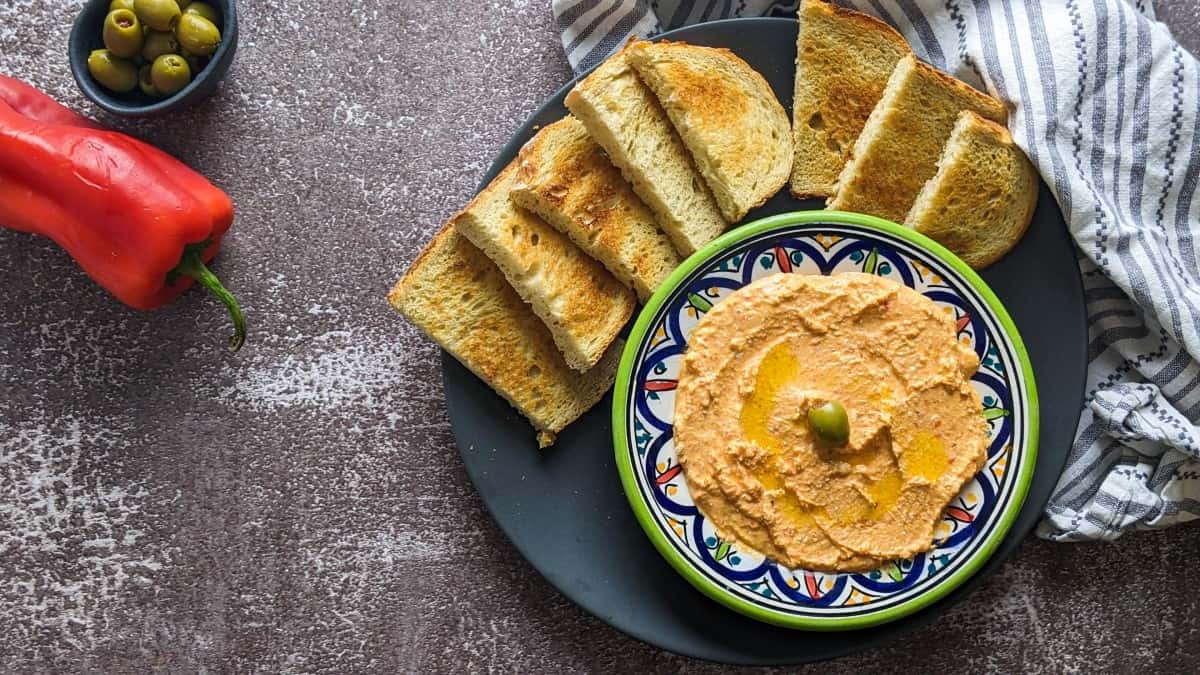 Tirokafteri dip served next to red pepper and bread.