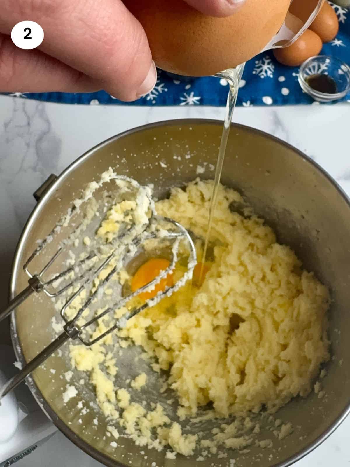 Adding one egg at a time to the bowl.