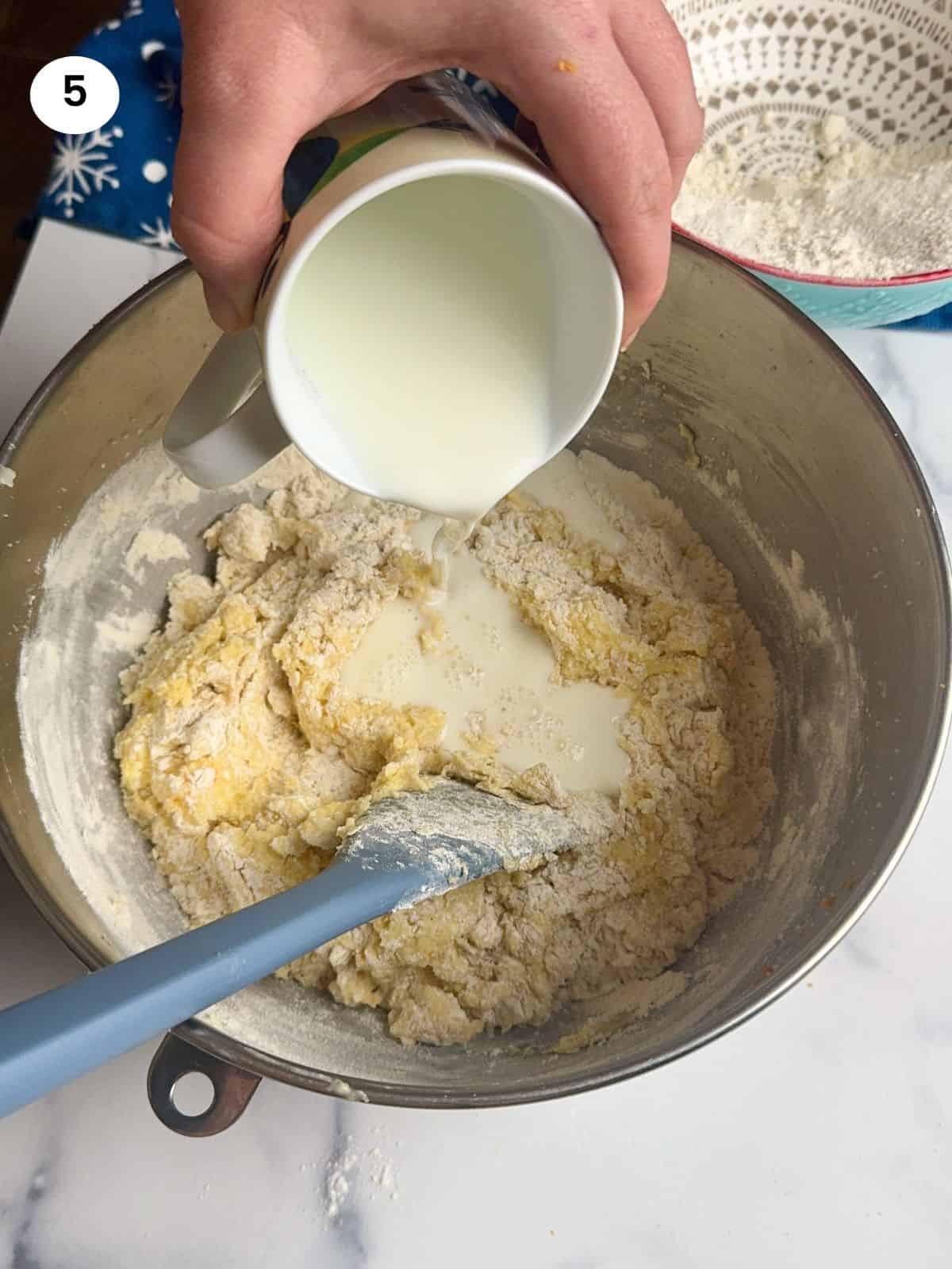 Adding the milk to the batter.