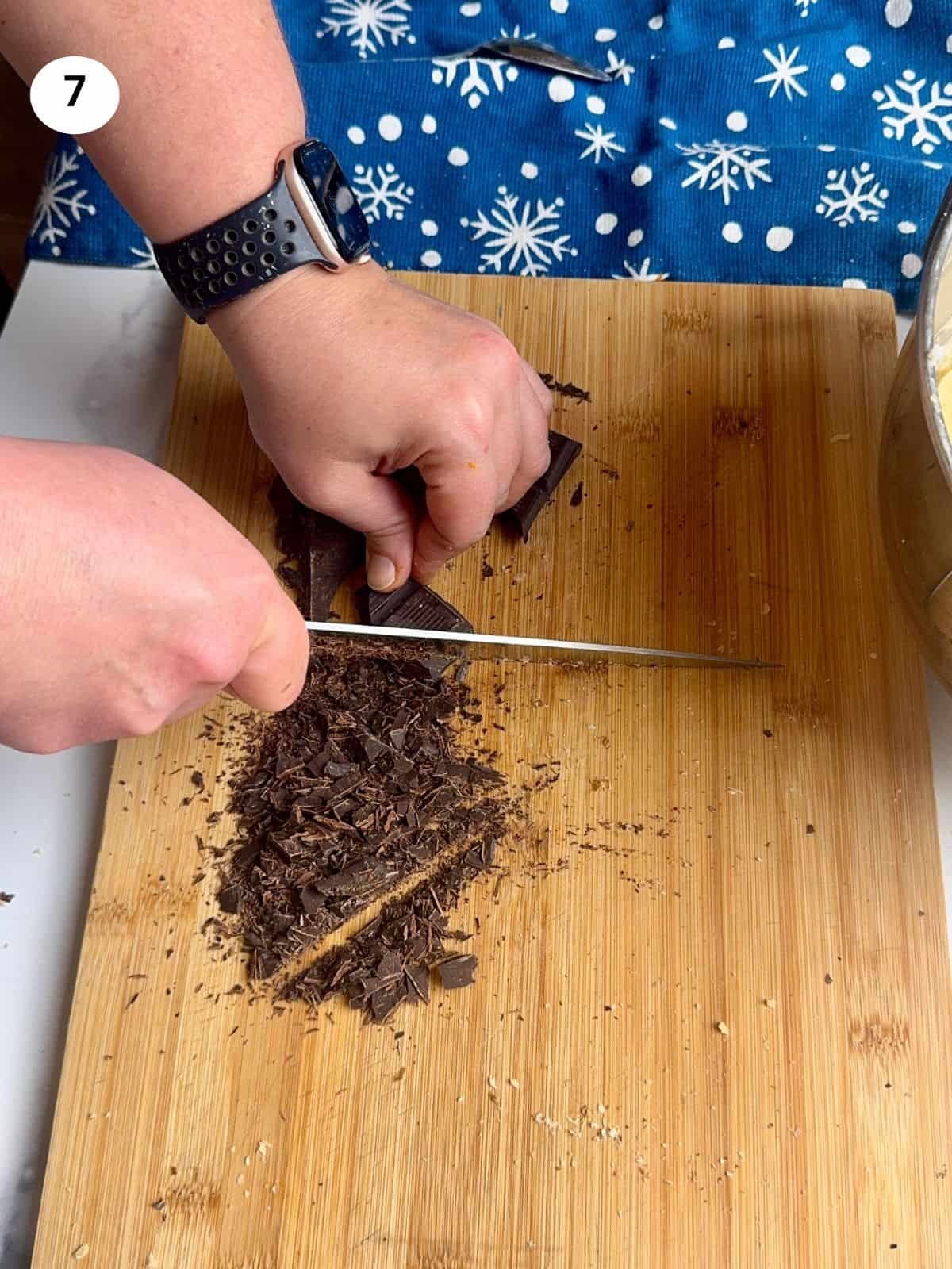 Chopping the chocolate bar with a knife.