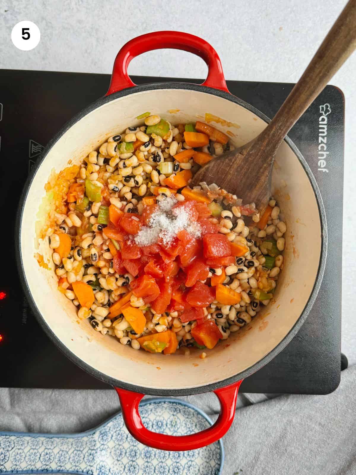 Adding the chopped tomatoes and seasoning to the pot.