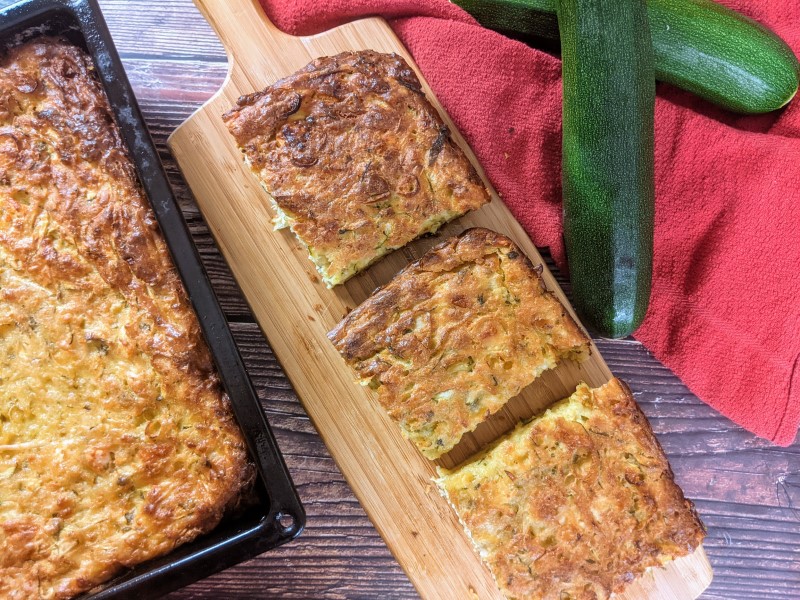 Three slices of crustless zucchini pie placed on a wooden board.